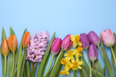 Photo of Beautiful flowers on light blue background, flat lay. Space for text