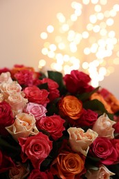 Photo of Beautiful bouquet of colorful roses on beige background, closeup