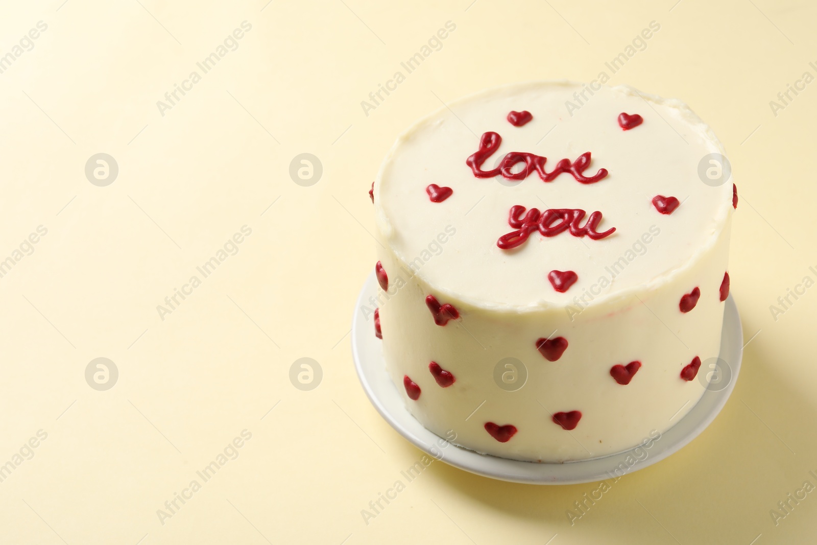 Photo of Bento cake with text Love You on beige table, space for text. St. Valentine's day surprise