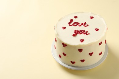 Photo of Bento cake with text Love You on beige table, space for text. St. Valentine's day surprise