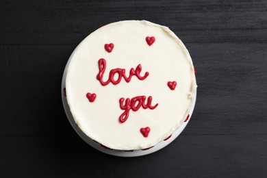 Photo of Bento cake with text Love You on black wooden table, top view. St. Valentine's day surprise