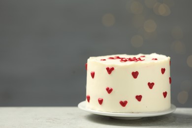 Photo of Bento cake with red cream hearts on grey table, space for text. St. Valentine's day surprise