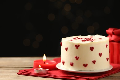 Photo of Bento cake, candles and gift box on wooden table, space for text. St. Valentine's day surprise