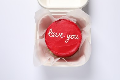 Photo of Bento cake with Love You text in takeaway box on white table, top view. St. Valentine's day surprise