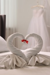 Photo of Honeymoon. Swans made of towels on bed in room