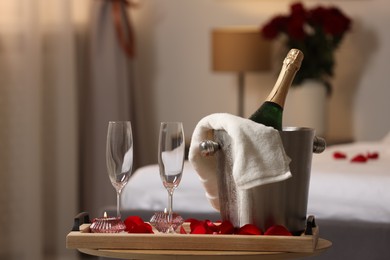 Photo of Honeymoon. Sparkling wine and glasses on wooden table in room