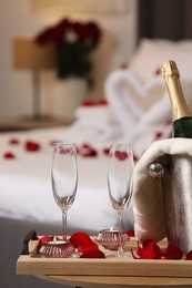 Photo of Honeymoon. Sparkling wine and glasses on wooden table in room