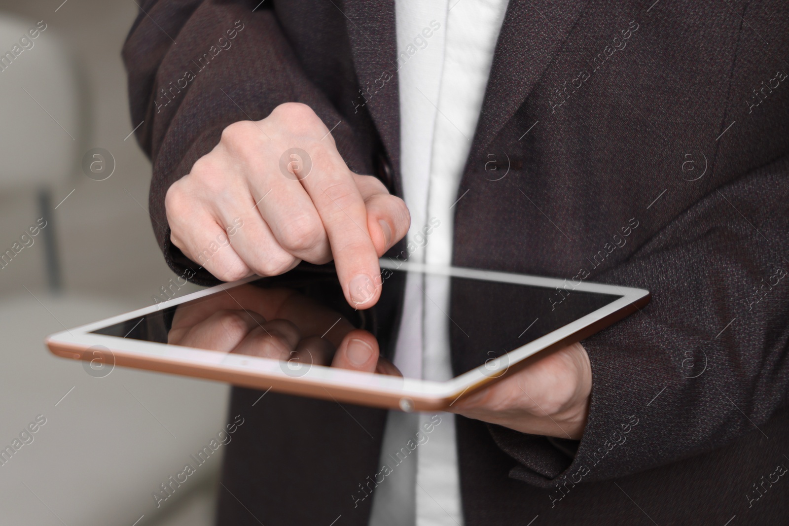 Photo of Businessman using tablet indoors, closeup. Modern technology