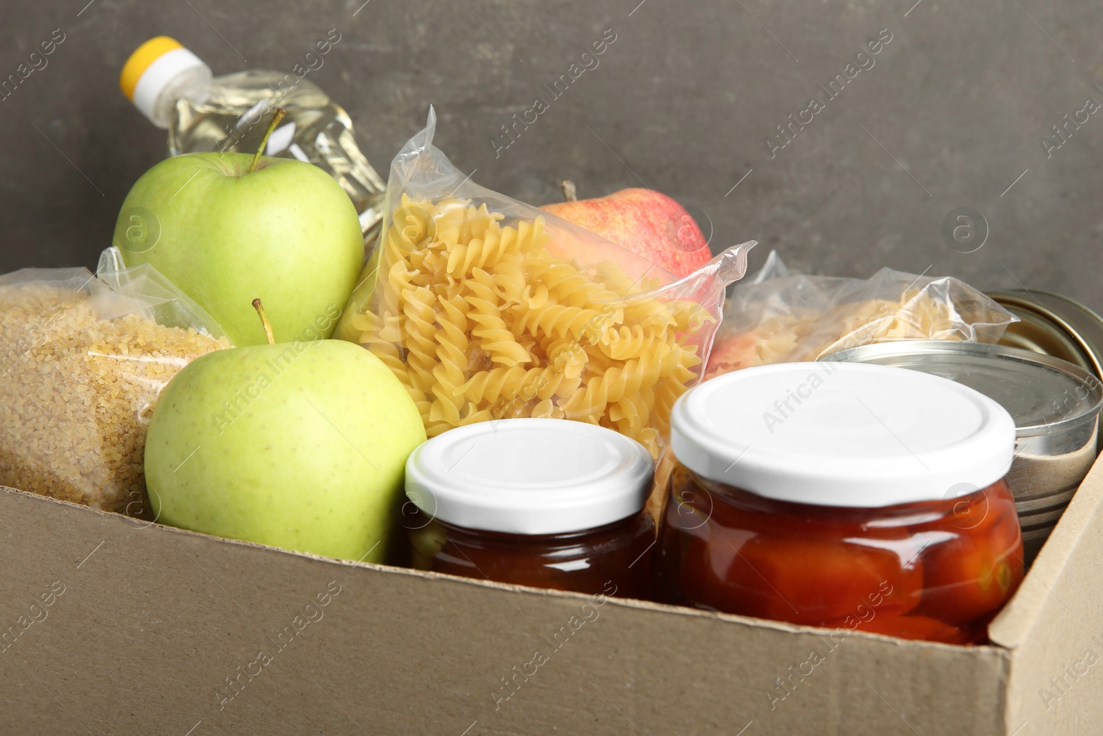 Photo of Different food products for donation in box, closeup