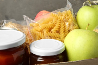 Photo of Different food products for donation in box, closeup