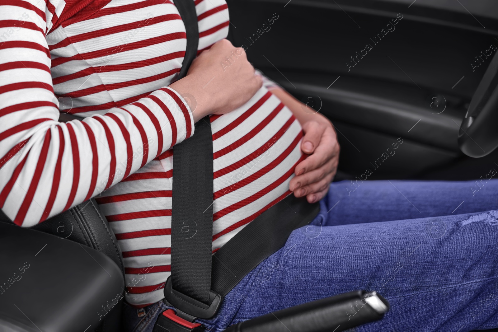 Photo of Pregnant woman with safety belt in car, closeup