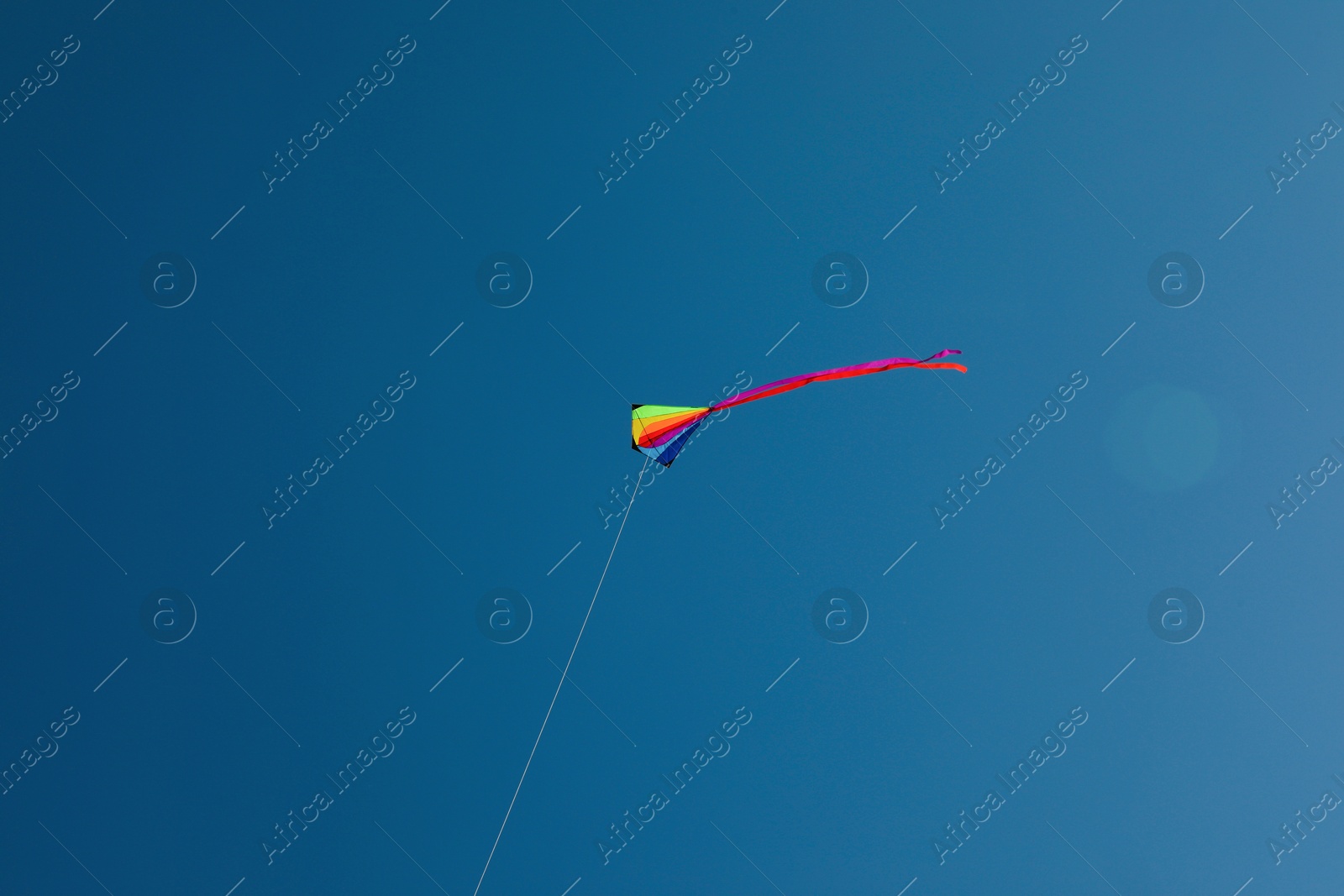 One colorful kite flying in blue sky Photo of One colorful kite flying in blue sky