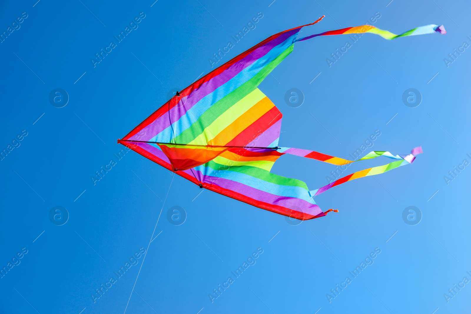 One colorful kite flying in blue sky Photo of One colorful kite flying in blue sky