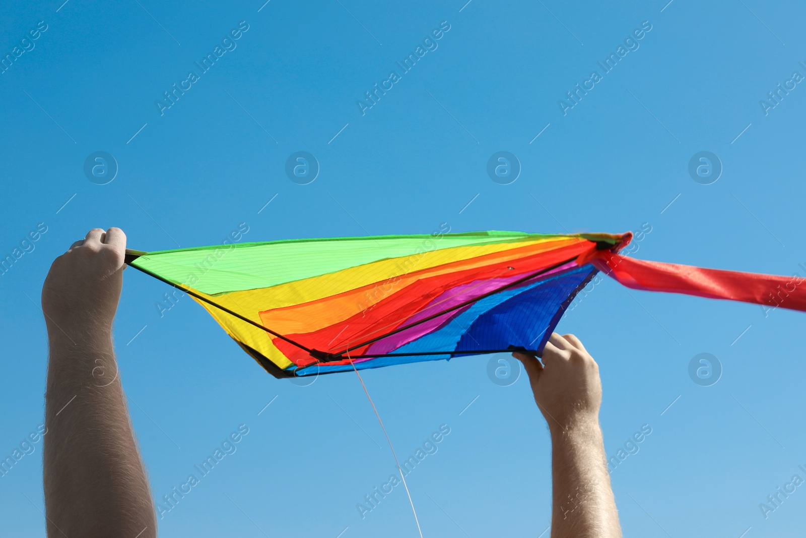 Man with kite against blue sky, closeup Photo of Man with kite against blue sky, closeup