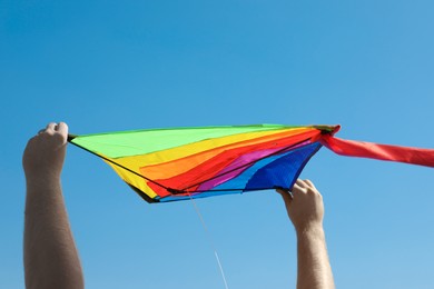 Photo of Man with kite against blue sky, closeup