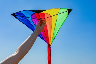 Photo of Man with kite against blue sky, closeup