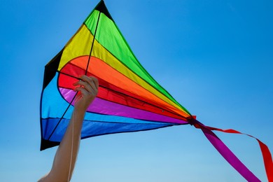 Photo of Man with kite against blue sky, closeup