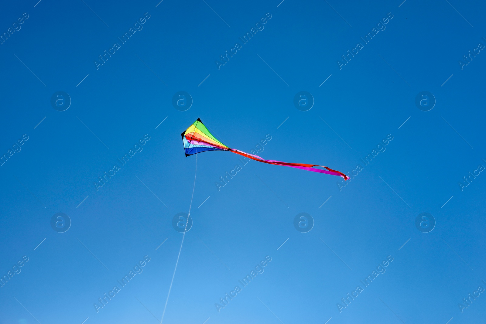 One colorful kite flying in blue sky Photo of One colorful kite flying in blue sky