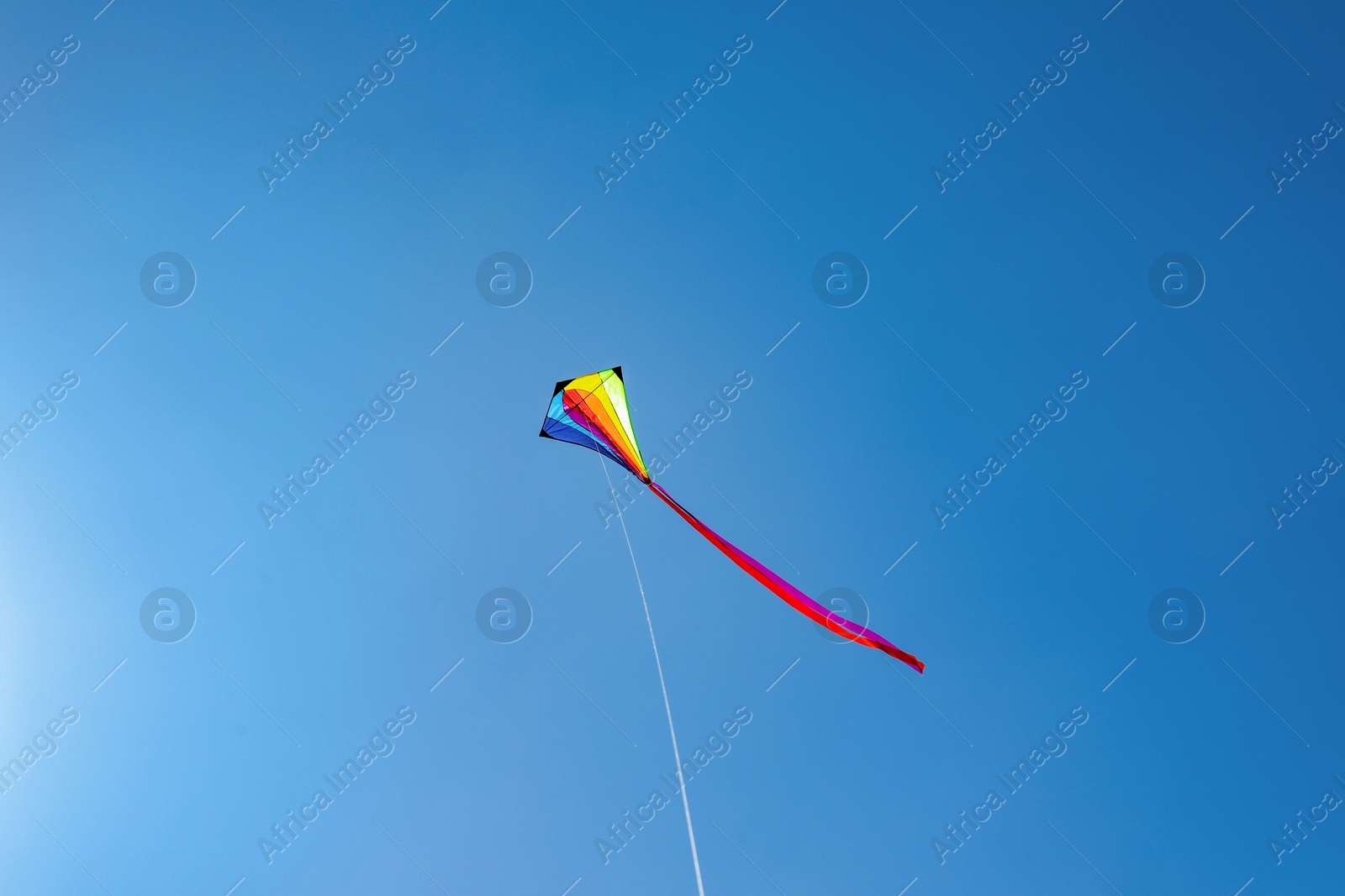 One colorful kite flying in blue sky Photo of One colorful kite flying in blue sky