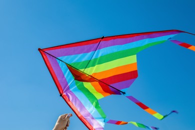 Photo of Woman with colorful kite against blue sky, closeup