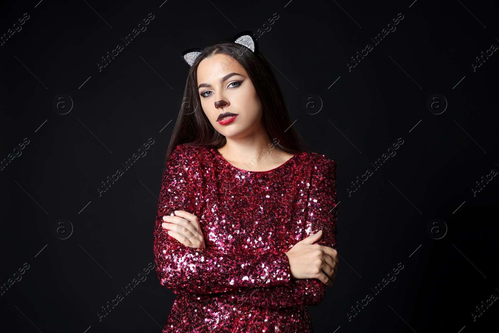 Photo of Charming woman with cat makeup and ears on black background