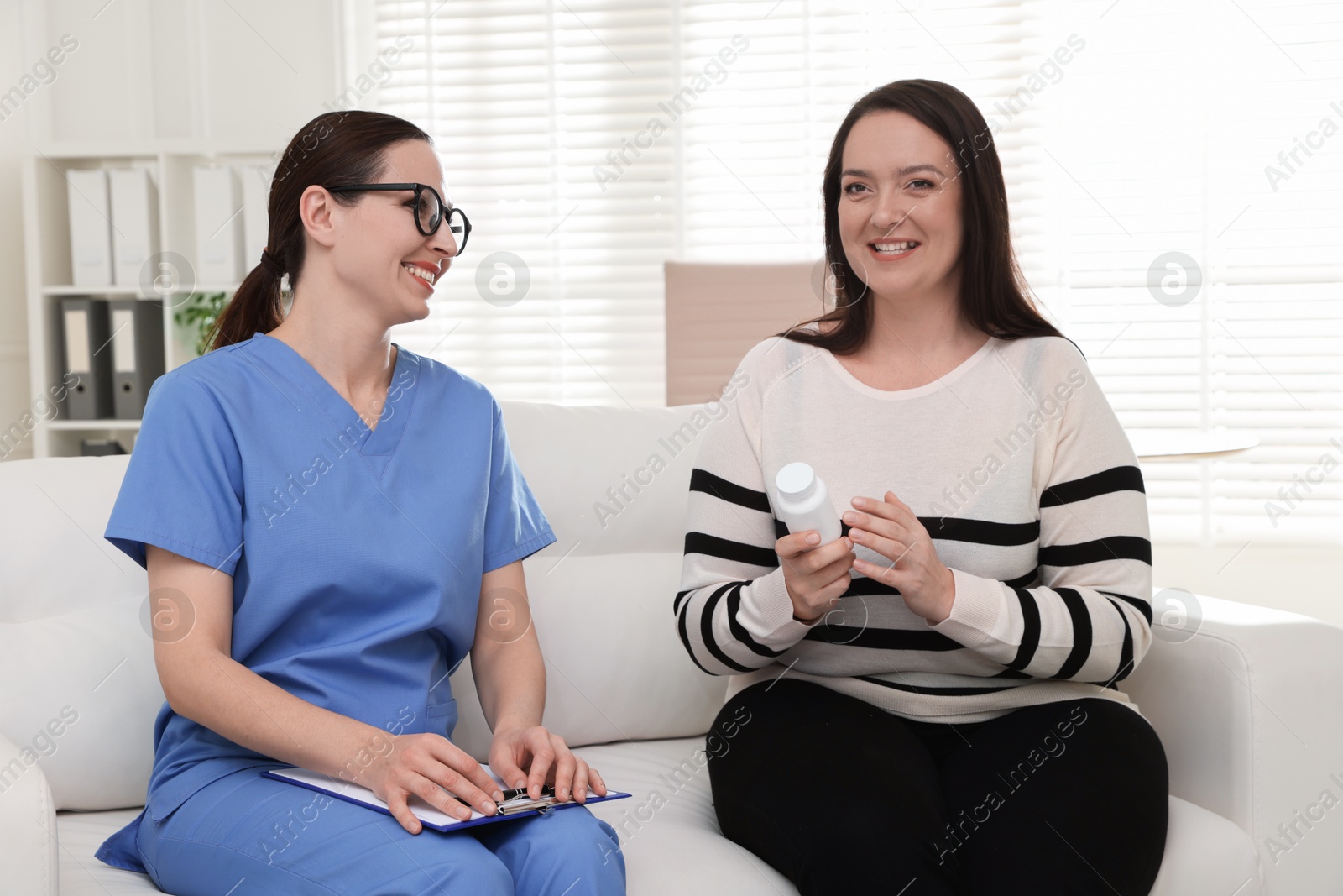 Photo of Nutritionist giving recommendations to overweight woman on couch in hospital