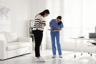 Photo of Nutritionist measuring plus size woman's weight in hospital