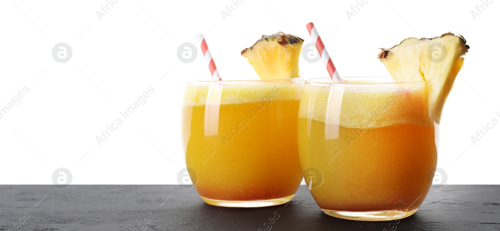 Photo of Tasty pineapple cocktail in glasses on black table against white background