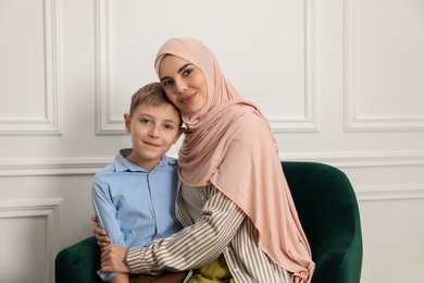 Photo of Muslim woman and her son spending time together at home