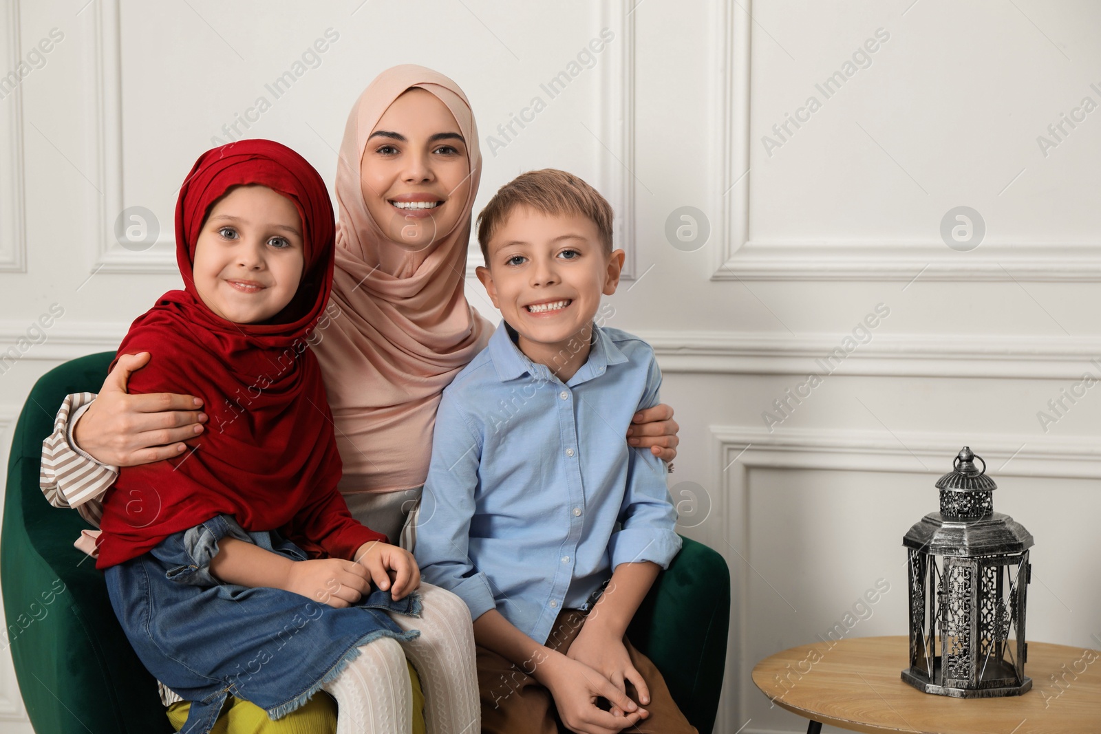 Photo of Muslim woman and her children spending time together at home