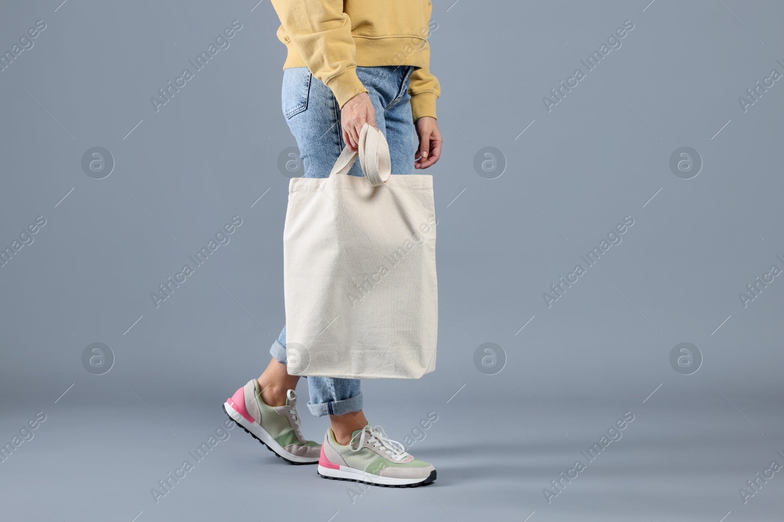 Photo of Woman with blank shopper bag on grey background, closeup. Mockup for design