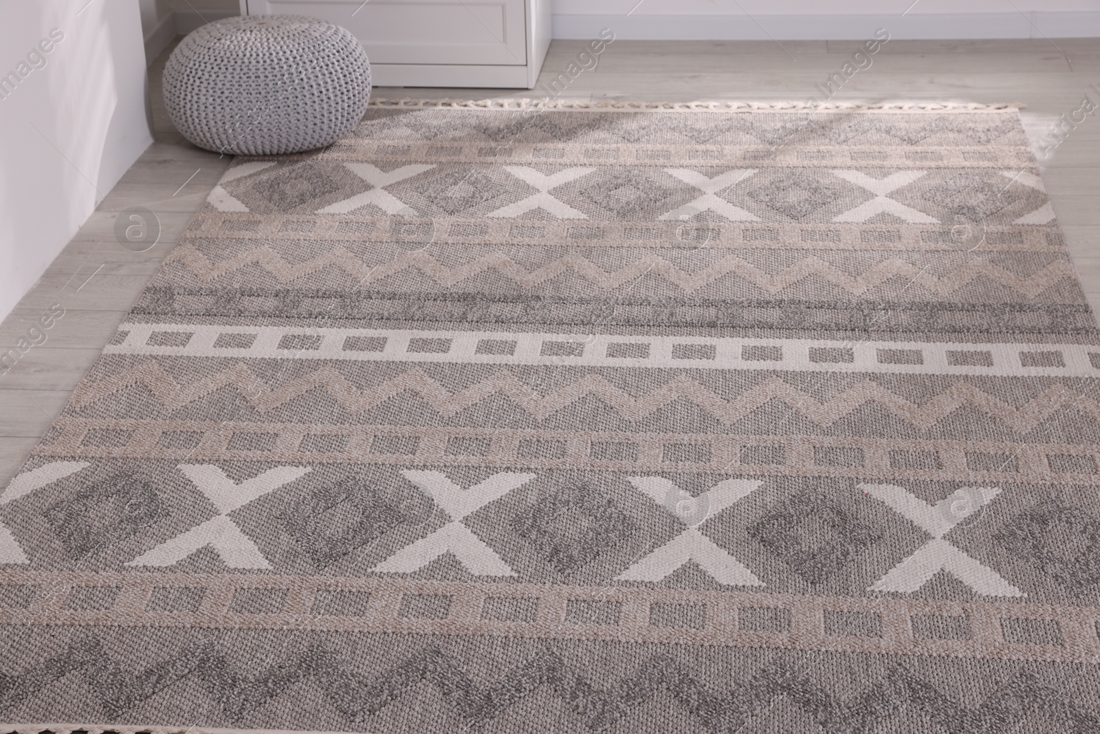 Photo of Stylish soft rug with pattern on floor indoors