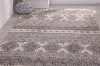Photo of Stylish soft rug with pattern on floor indoors