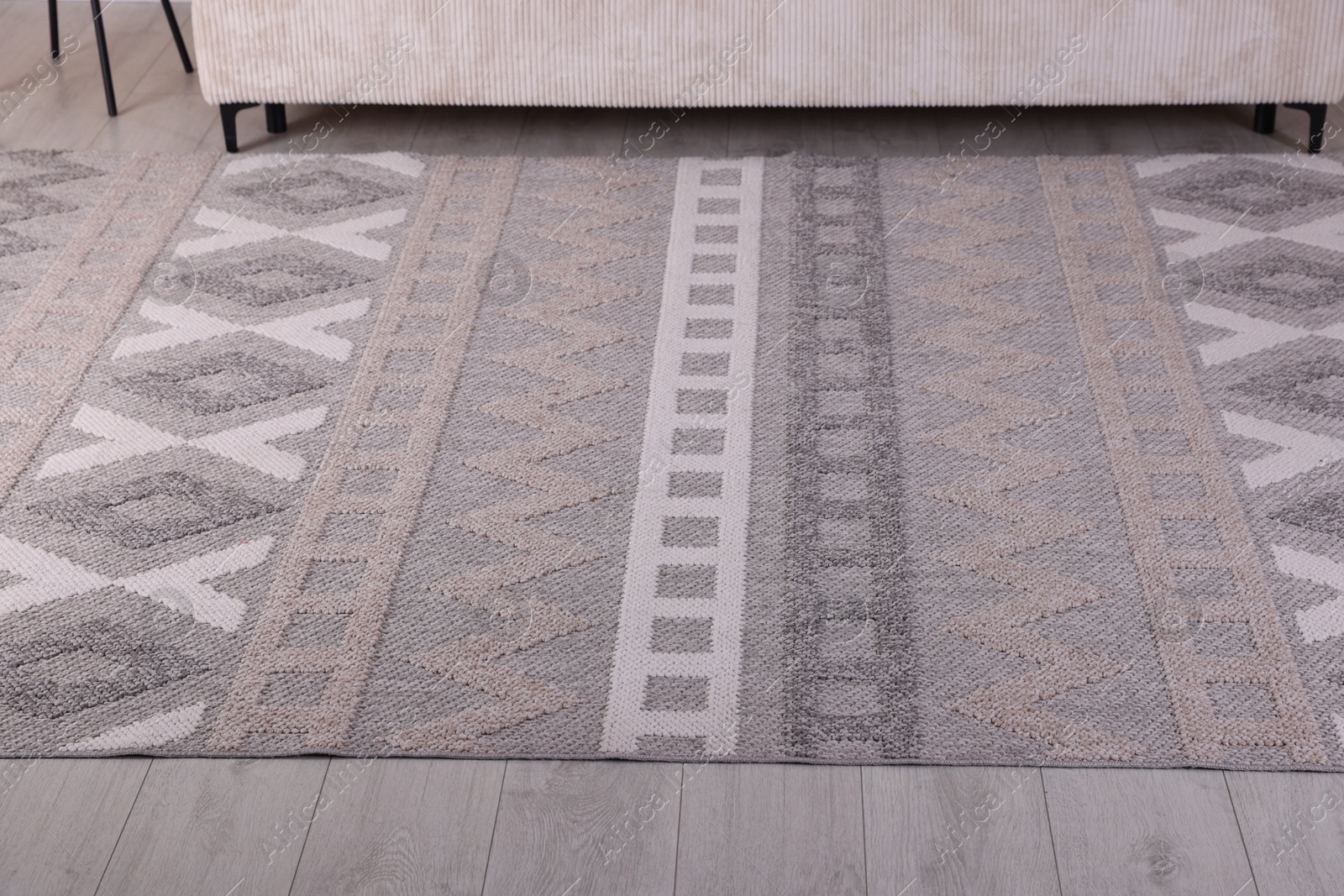 Photo of Stylish soft rug with pattern on floor indoors