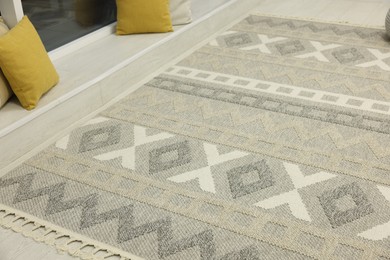 Photo of Stylish rug with pattern on floor indoors