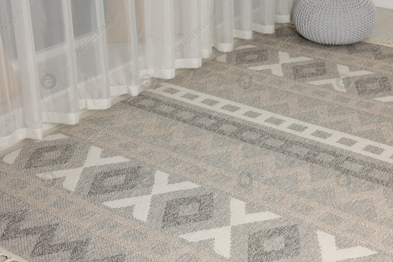 Stylish rug with pattern on floor indoors Photo of Stylish rug with pattern on floor indoors