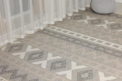 Photo of Stylish rug with pattern on floor indoors