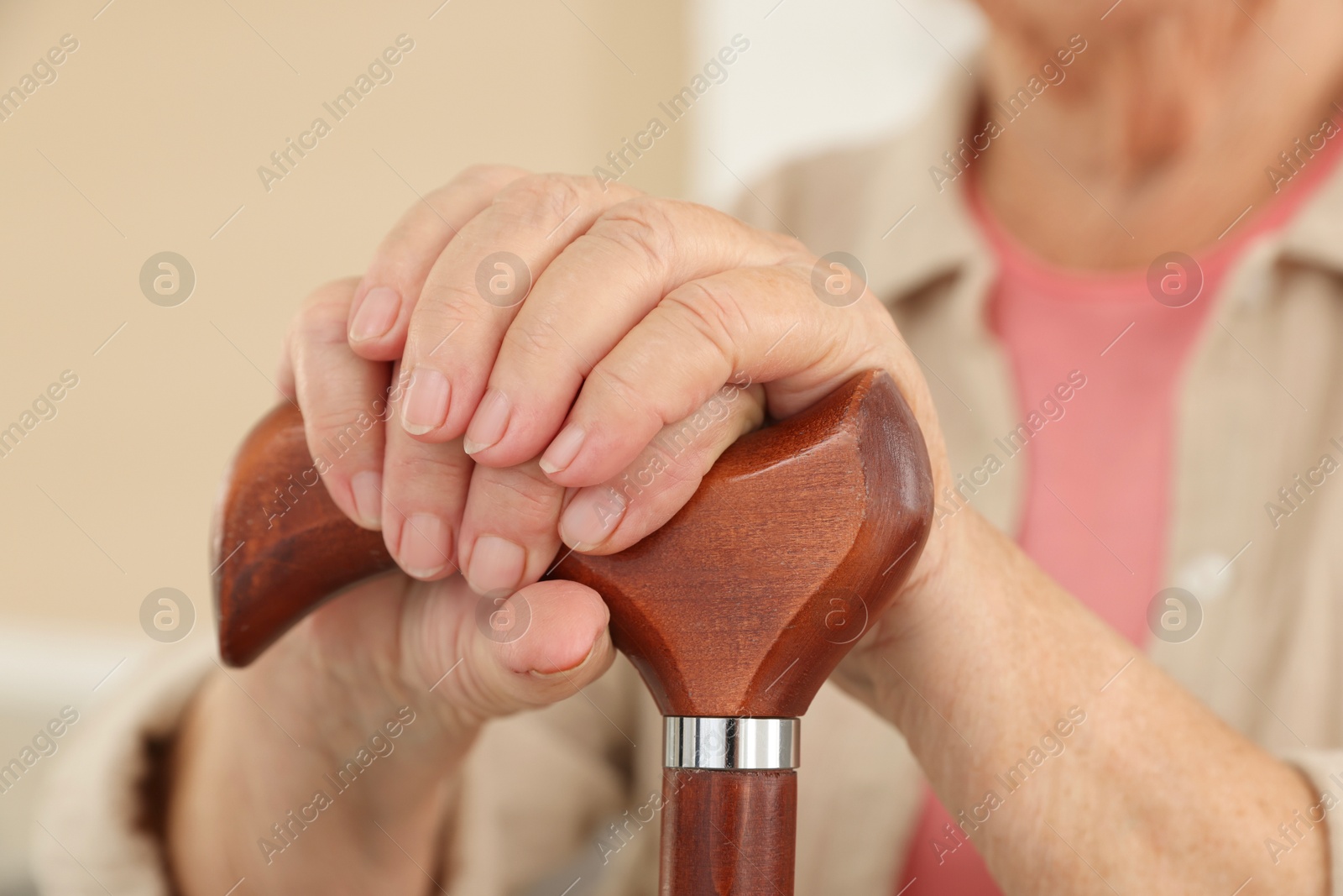 Photo of Senior woman with walking cane indoors, closeup