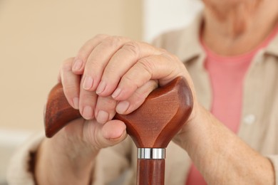 Senior woman with walking cane indoors, closeup