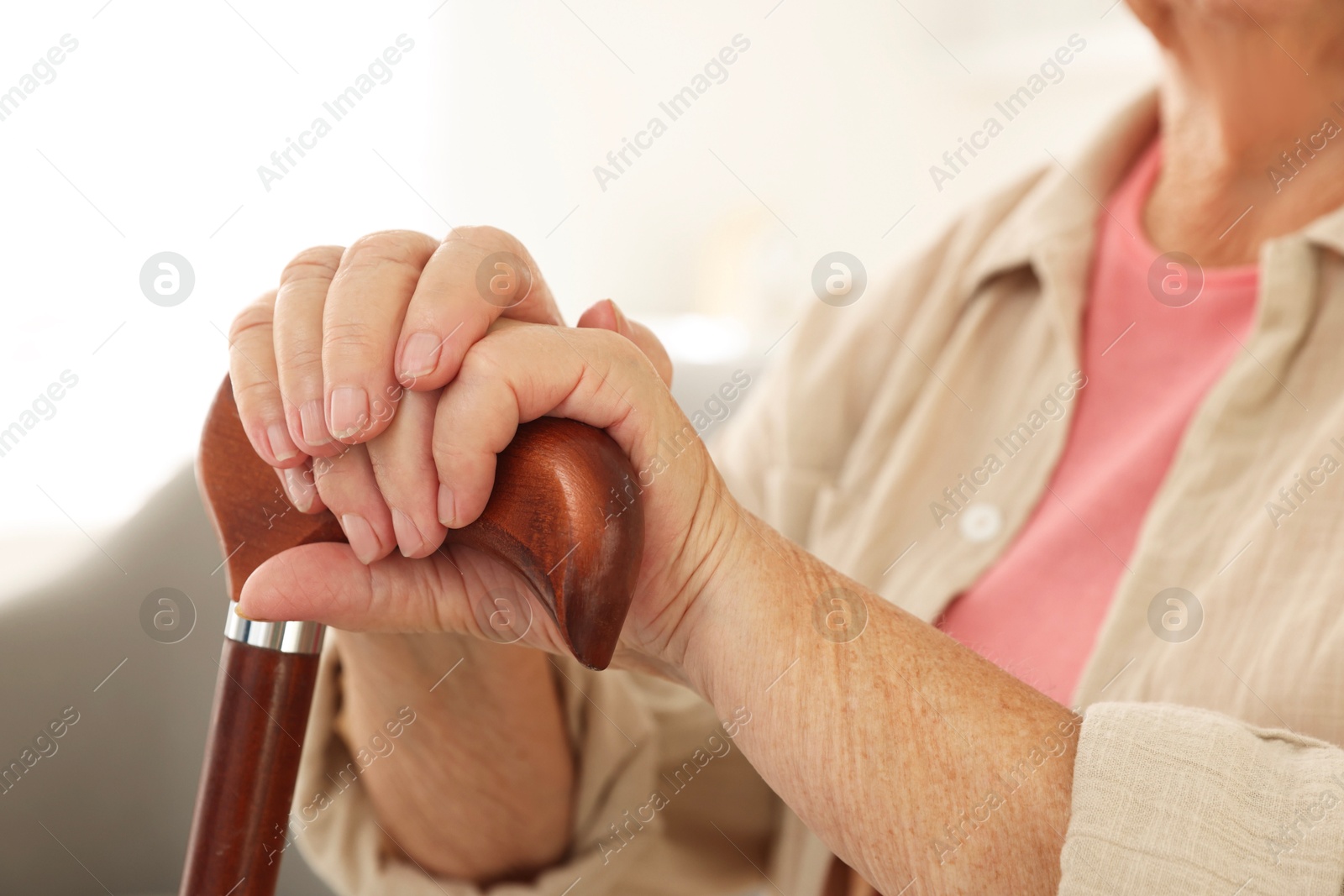 Photo of Senior woman with walking cane indoors, closeup