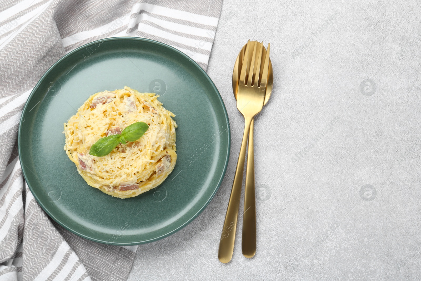 Photo of Delicious pasta Carbonara served on gray table, flat lay. Space for text