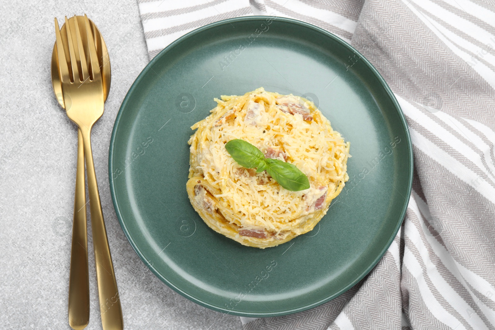 Photo of Delicious pasta Carbonara served on gray table, flat lay