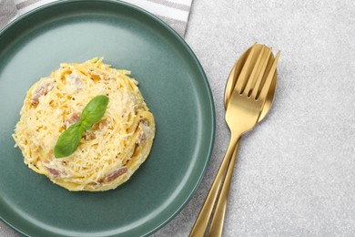 Photo of Delicious pasta Carbonara served on gray table, flat lay