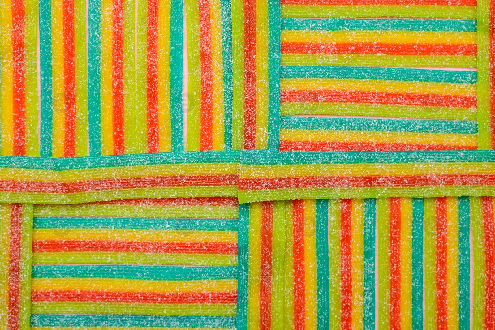 Photo of Tasty rainbow sour belts as background, top view