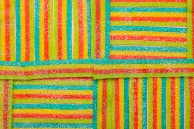 Photo of Tasty rainbow sour belts as background, top view