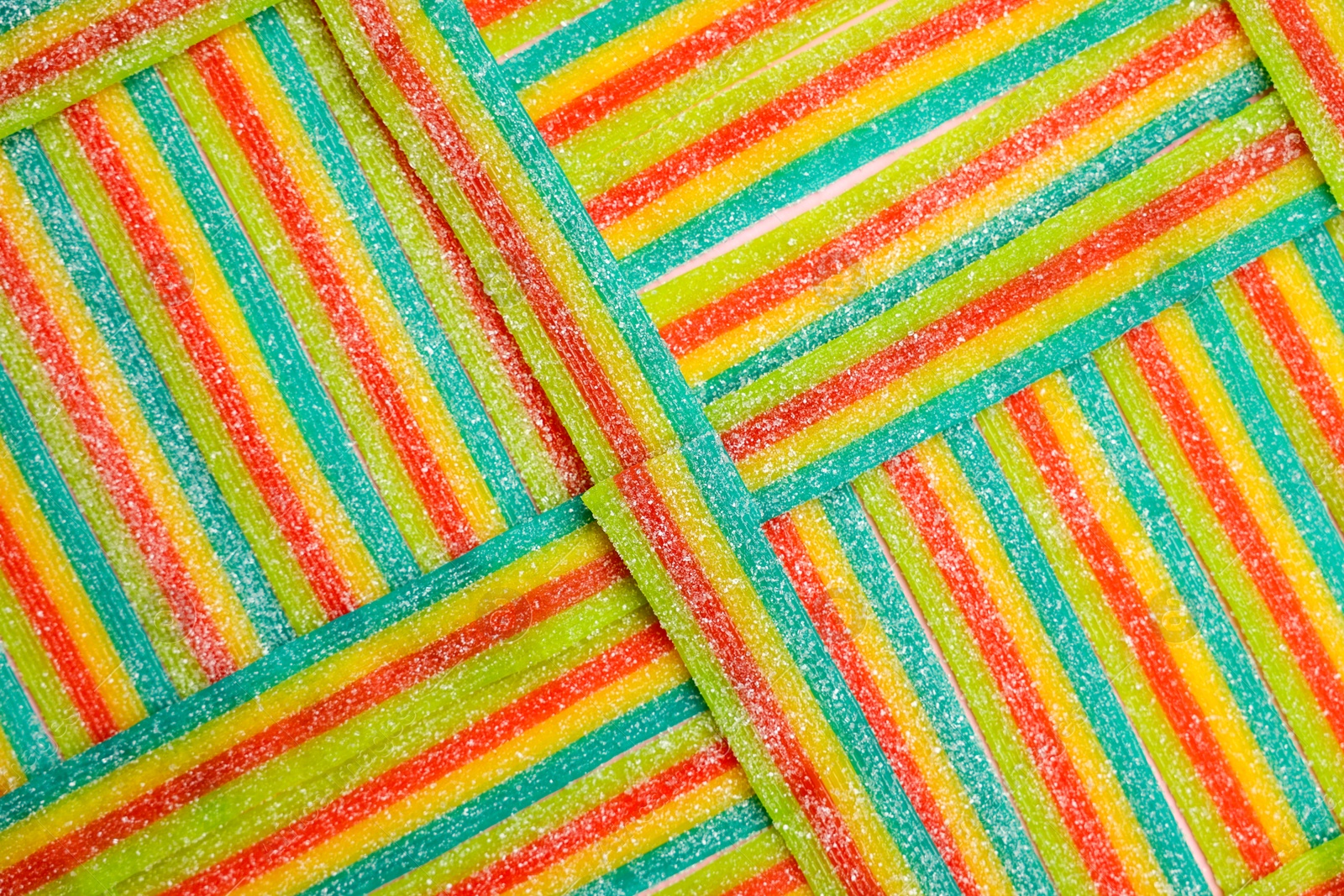 Photo of Tasty rainbow sour belts as background, top view