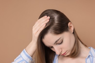 Photo of Girl with hair loss problem on dark beige background