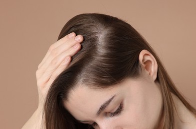 Photo of Girl with hair loss problem on dark beige background