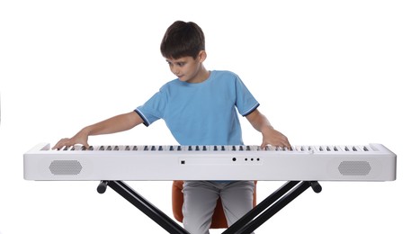 Photo of Cute boy playing synthesizer on white background