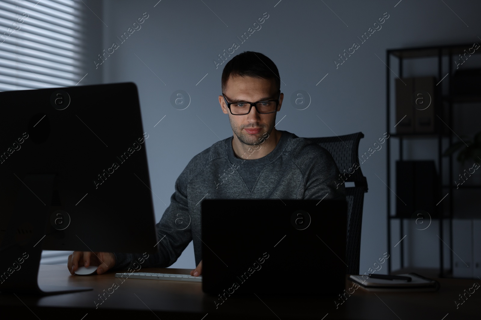 Photo of Programmer working on laptop indoors at night